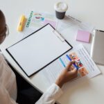 Top view of a woman reviewing various documents with a clipboard on a desk.